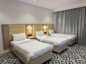 a hotel room with two beds in a room at Al Madinah Hotel in Al Madinah