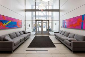 ein Wohnzimmer mit Sofas und eine Lobby mit farbenfrohen Gemälden in der Unterkunft Corporate Stays Hendrix - 2 Bedrooms in Edmonton