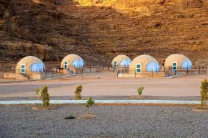 un gruppo di cupole di fronte a una montagna di Desert calm a Wadi Rum Altre 35 foto