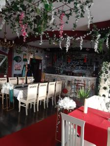 een restaurant met een tafel, witte stoelen en bloemen bij Stone dream in Polje