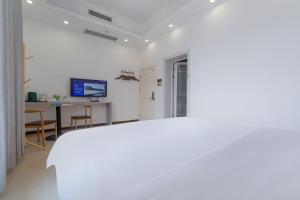 a white room with a table and a desk at Hua Han Hotel in Zhangjiajie