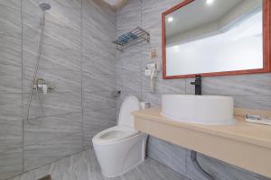 a bathroom with a toilet and a mirror and a shower at Hua Han Hotel in Zhangjiajie