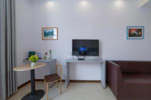 a room with a couch and a table with a television at Hua Han Hotel in Zhangjiajie +8 photos