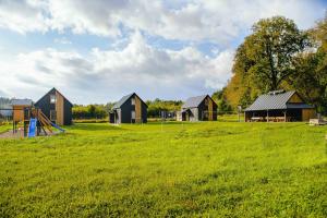 HuwnikiにあるDomki nad Wiarem 2の遊び場のある畑の家々