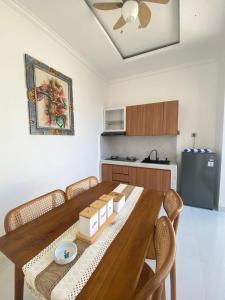 a dining room table with chairs and a kitchen at Villa Bulan by MentariPro Bali in Singaraja