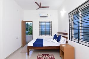 ein Schlafzimmer mit einem Bett mit Deckenventilator in der Unterkunft Pondicherry Comfort Rooms in Puducherry