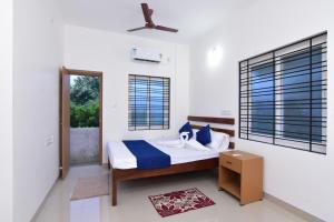a bedroom with a bed and a ceiling fan at Pondicherry Comfort Rooms in Puducherry
