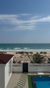 a house with a swimming pool next to a beach at شالية ماربيا الاشخرة Marbella Ashkhara Chalet in Al Ashkharah