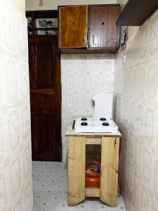 a small kitchen with a stove and a sink at Mombasa Town CBD Studio in Mombasa +4 photos