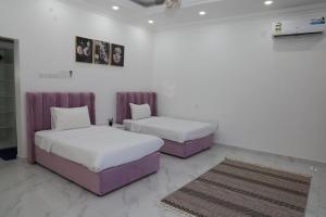 two beds in a room with white and purple at شالية ماربيا الاشخرة Marbella Ashkhara Chalet in Al Sharqiyah