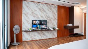 a living room with a tv on a marble wall at Son Tra homestay in Danang