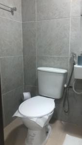 a bathroom with a white toilet and a sink at Flat funcional mobiliado com cozinha e WC privativo apt106 in Recife +12 photos