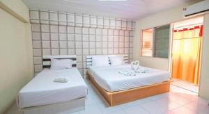 ein Schlafzimmer mit zwei Betten und einem Fenster in der Unterkunft Nornnan Hotel in Nan + 160 Fotos