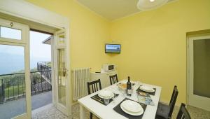 una sala da pranzo con tavolo e balcone di La vista dal borgo a Toscolano Maderno