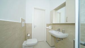 un bagno con un water bianco e un lavandino di La vista dal borgo a Toscolano Maderno Altre 30 foto