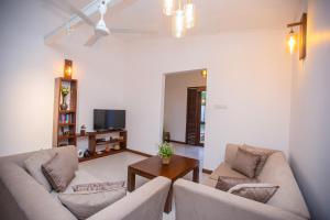 a living room with two couches and a table at Villa D8 in Mirissa