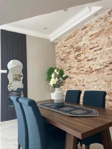 a dining room with a wooden table and blue chairs at شالية ماربيا الاشخرة Marbella Ashkhara Chalet in Al Ashkharah