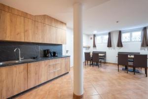 ピーゼンドルフにあるApartment Kitzsteinhornのキッチン(木製キャビネット、テーブル、椅子付)