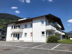 ピーゼンドルフにあるApartment Kitzsteinhornの駐車場のある大きな白い建物
