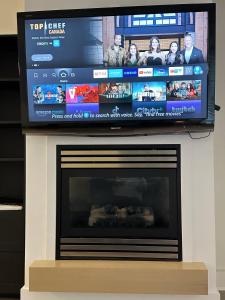 Modern 3-Bedroom Apartment in UBC في فانكوفر: مدفأة و شاشة تلفزيون مسطحة فوقها