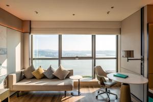 a living room with a couch and a large window at Shantou Marriott Hotel in Shantou