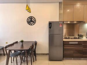 a kitchen with a table and a refrigerator at R&F Princess Cove 2BR, JB CIQ, Shopping Malls, by Good Life Homestay in Johor Bahru