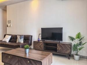 a living room with a television and a couch at R&F Princess Cove 2BR, JB CIQ, Shopping Malls, by Good Life Homestay in Johor Bahru