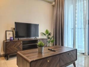a living room with a television and a coffee table at R&F Princess Cove 2BR, JB CIQ, Shopping Malls, by Good Life Homestay in Johor Bahru