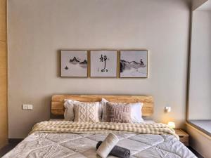 a bedroom with a bed with four pictures on the wall at R&F Princess Cove 3BR, Sea View, JB CIQ, by Good Life Homestay in Johor Bahru