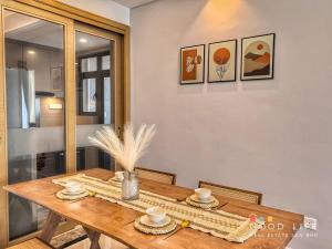 a wooden table with two cups and plates on it at R&F Princess Cove 2, 3BR, Sea View, JB CIQ, by Good Life Homestay in Johor Bahru