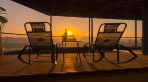 two chairs and a table on a balcony with a sunset at BBQ Hotel with Swimming Pool in Lạng Sơn in Lạng Sơn
