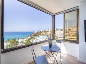 un tavolo con sedie in una camera con vista sull'oceano di Aguila Beach Ocean View By CanariasGetaway a San Agustin