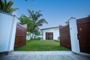 an entrance to a house with two wooden gates at Villa D8 in Mirissa