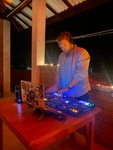アハンガマにあるWalawwa Villa KathaluwaのDJ機器のあるテーブルの横に立っている男性