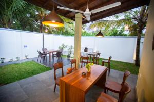 a patio with tables and chairs in a yard at Villa D8 in Mirissa