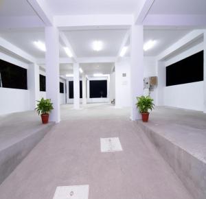 an empty room with white walls and potted plants at Pondicherry Comfort Rooms in Puducherry