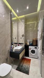 ein Badezimmer mit Waschbecken und Waschmaschine in der Unterkunft SeaBreeze Lighthouse 114 in Baku