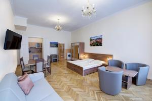 a living room with a bed and a dining room at Apartments Paderewski in Karlovy Vary