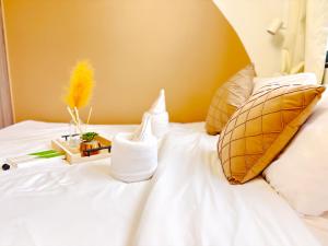 a bed with white sheets and pillows and a yellow wall at Casita Aroha SHORE 2 B02-19114 in Sampong