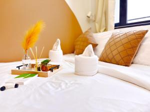 a white bed with a tray of items on it at Casita Aroha SHORE 2 B02-19114 in Sampong