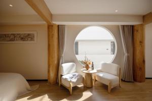 a bedroom with a bed and a table and chairs at Yunlanli Mountainside Homestay in Shangri-La