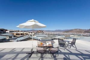a table and chairs with an umbrella on a roof at Yunlanli Mountainside Homestay in Shangri-La