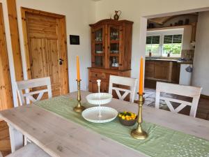 a dining room table with two candles and fruit on it at Idylle am See in Zossen