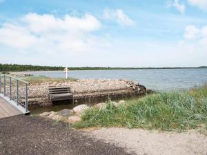 a dock on a lake with a person standing on it at 6 person holiday home in Juelsminde-By Traum in Juelsminde
