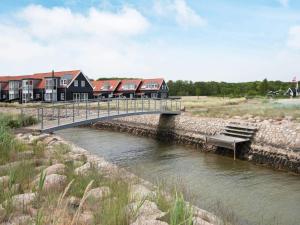 a bridge over a river with a group of houses at 6 person holiday home in Juelsminde-By Traum in Juelsminde +31 photos