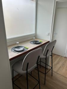 un tavolo con due sedie e due piatti sopra di Cozy studio a Quessoy