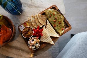 a table with a plate of food with guacamole and dip at The Cloud Xpress in Nathia Gali