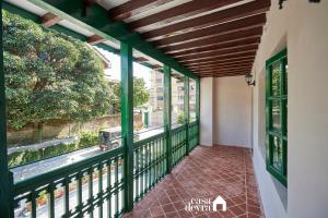 einen Balkon eines Hauses mit grünem Geländer in der Unterkunft Hajuri Kunj Bungalow in Kathmandu
