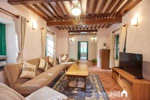 ein Wohnzimmer mit Sofa und Fernseher in der Unterkunft Hajuri Kunj Bungalow in Kathmandu