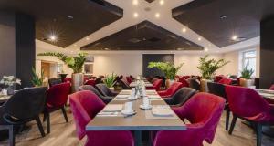 a dining room with a long table and red chairs at PLAZA INN Grevenbroich in Grevenbroich +47 photos